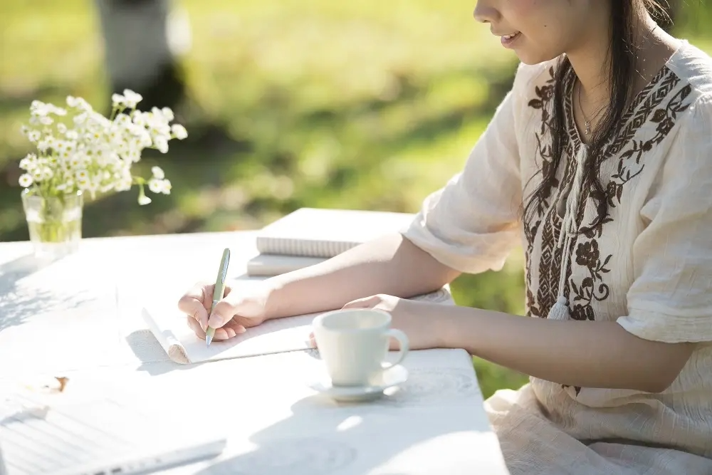 親しみを込めてプランナーへのお礼の手紙を書く新郎新婦のイメージ