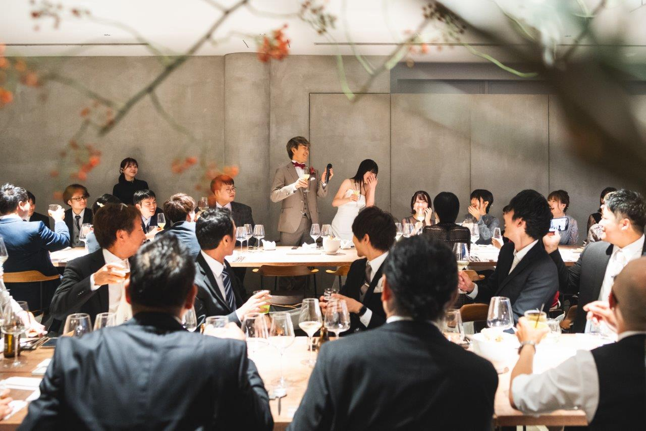 IWAI OMOTESANDOのゲスト中心の温かな結婚式で、新郎新婦とゲストが笑顔で語り合うアットホームなパーティーの様子