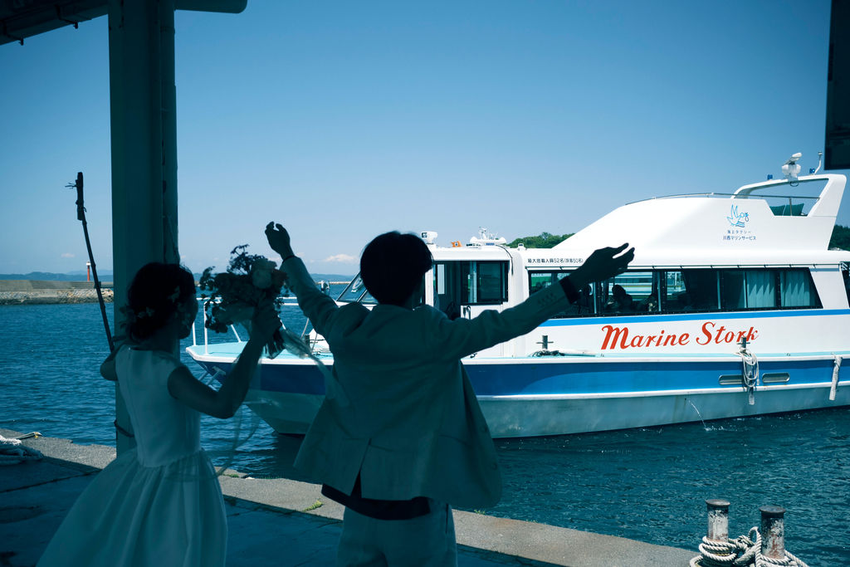 島の住民たちと新郎新婦が笑顔で交流する、心温まる結婚式のワンシーン