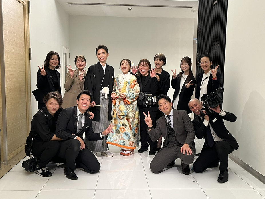 鶴見ノ森迎賓館の「ワンチーム」スタッフが和気あいあいと集まり、最高の結婚式を創り上げるための強い絆を示す様子