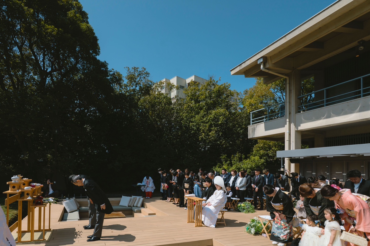 緑豊かなTHE SORAKUENの日本庭園で、ゲストに見守られながら行われるガーデンウェディングの様子。