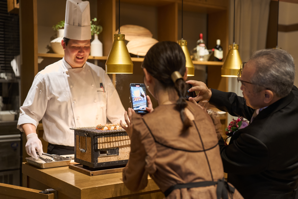 大きな一つのテーブルを囲み、オープンキッチンも備えたTHE CLASSICA omotesandoの少人数向け会場での会食風景