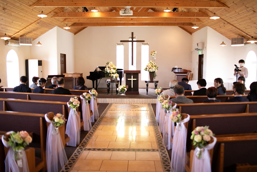 スタッフの手で作られた温かみのある独立型チャペル。祭壇奥のガラス窓から自然光が降り注ぎ、木のぬくもりに包まれた神聖な空間